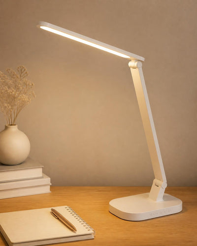 Lampe de bureau Alba allumée sur un bureau